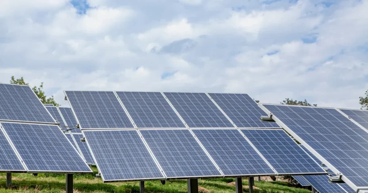 Solar panels in a field under a cloudy sky