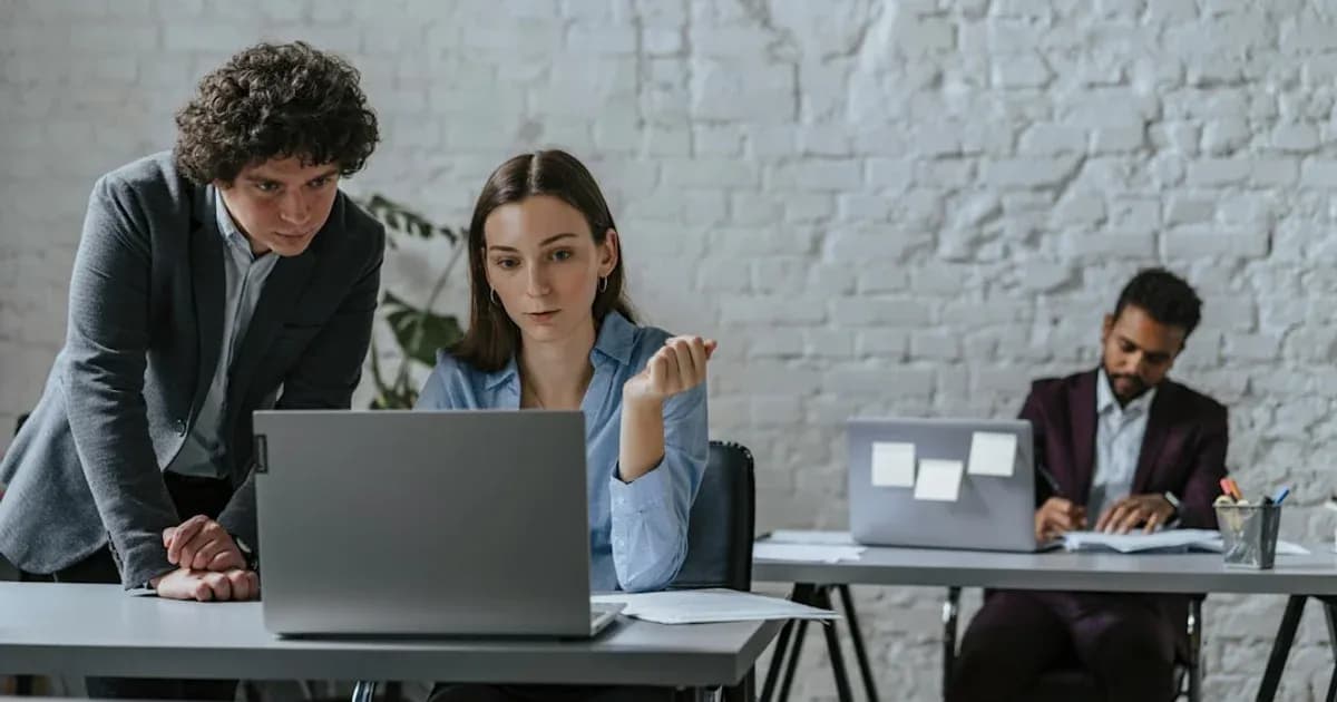 Two colleagues collaborating on a laptop in office.