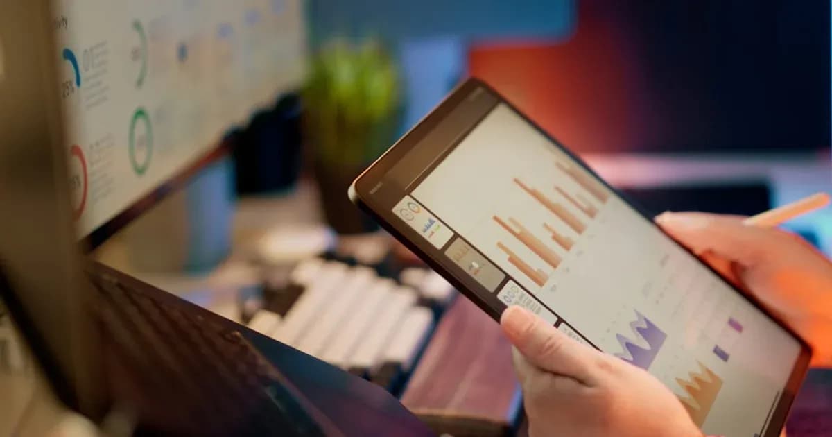 Someone analyzes financial data on a tablet.