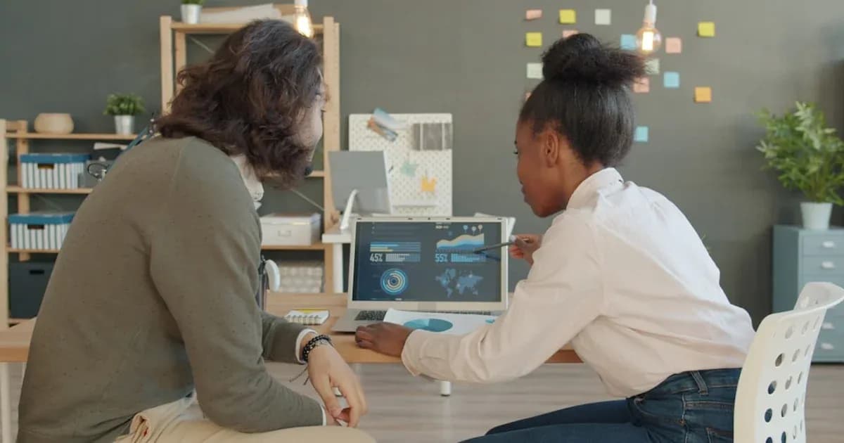Two people looking at data on a laptop screen